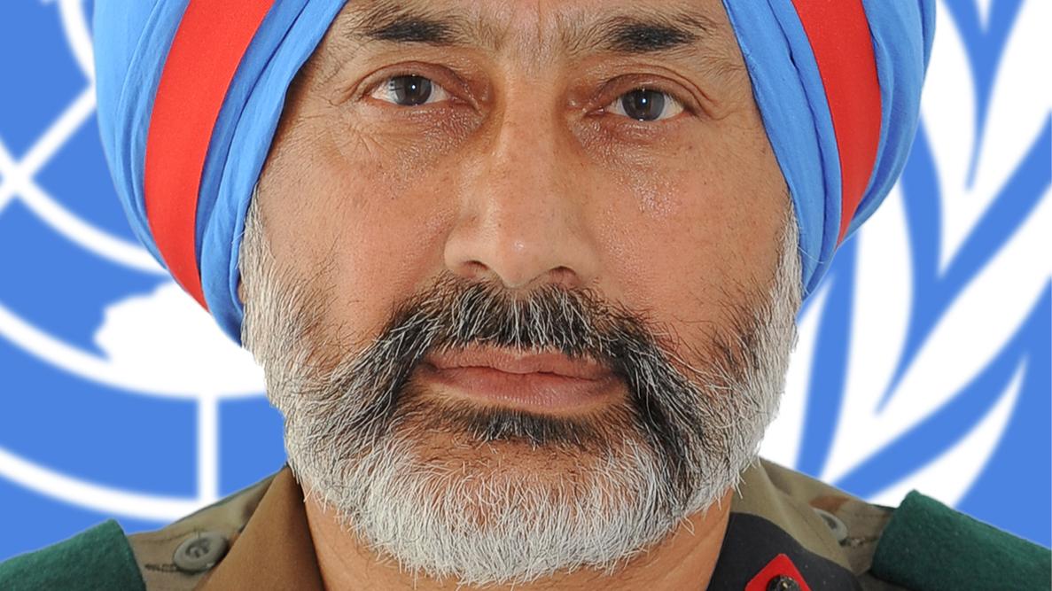 A headshot of a man in military uniform in front of a UN logo